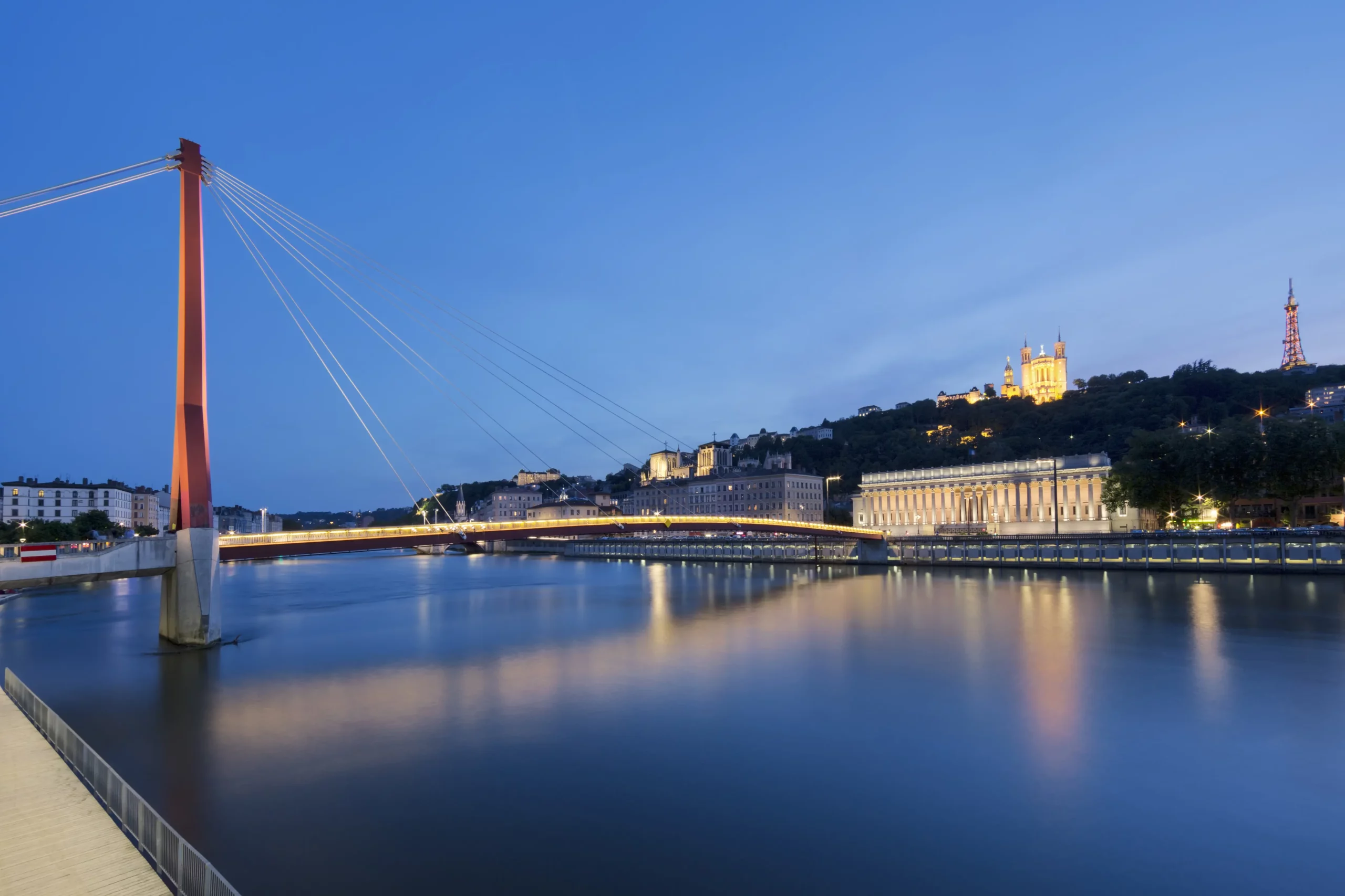 Pont moderne éclairé sur la rivière, ville illuminée la nuit, création de site web à Nantes