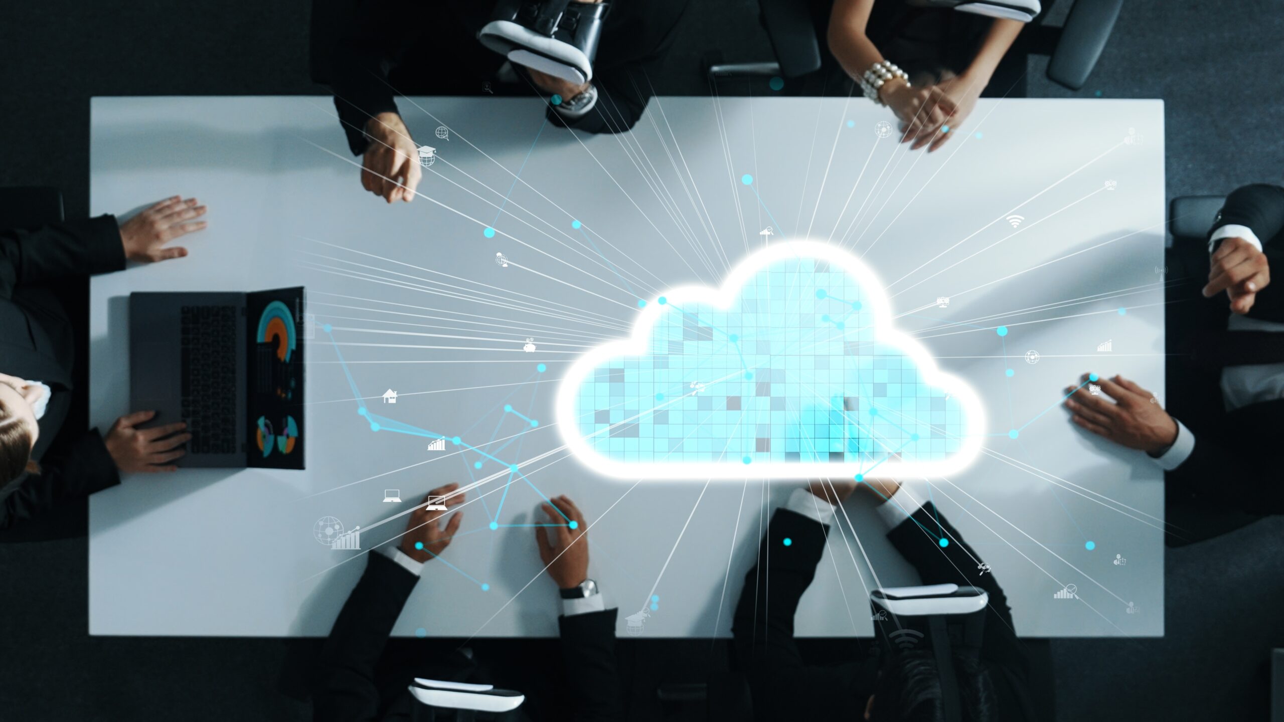 Des professionnels en réunion autour d’une table blanche, portant des casques VR, interagissant avec un nuage holographique de données.