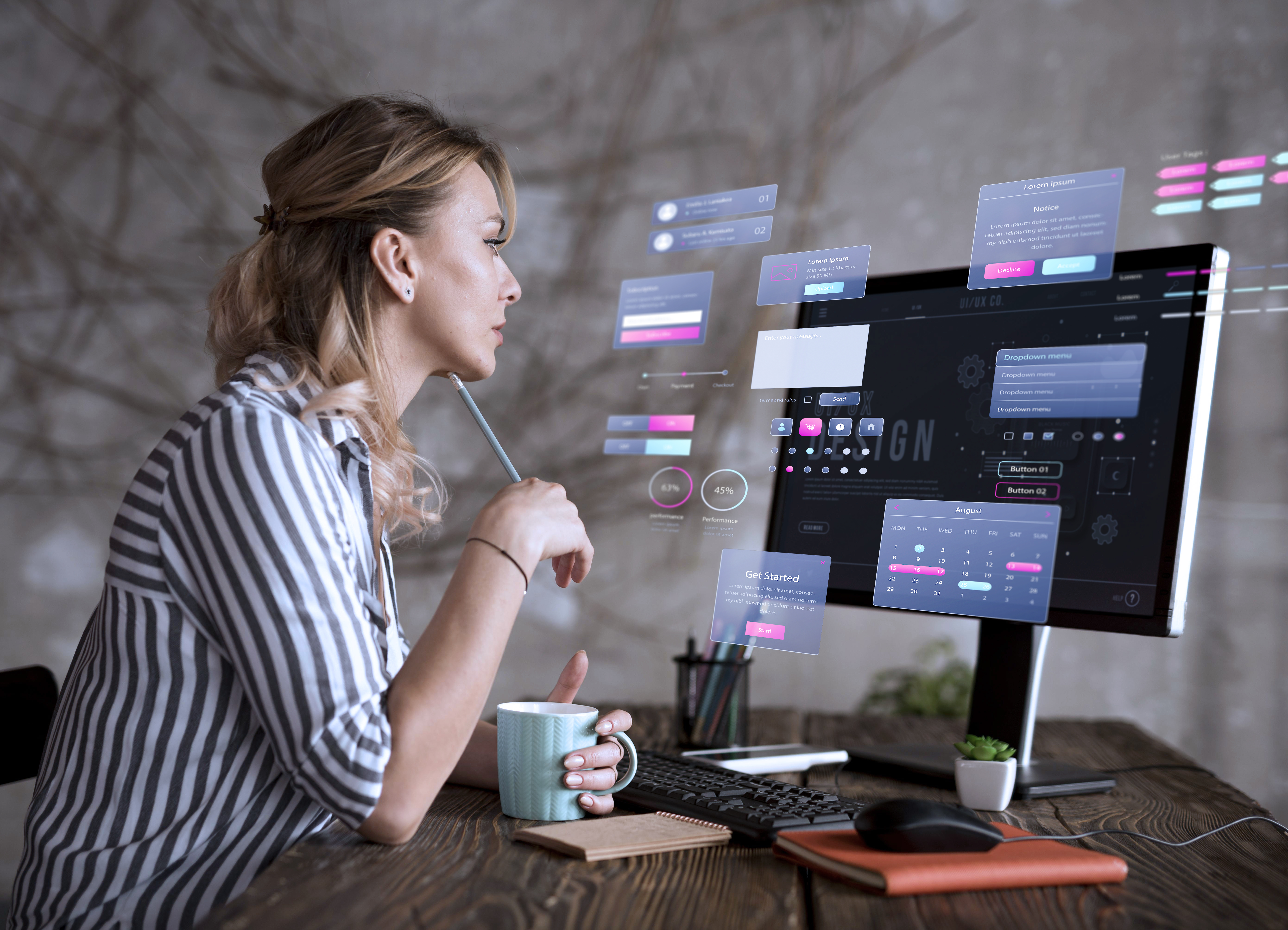 Femme concentrée devant un écran avec des éléments d’interface utilisateur en réalité augmentée.